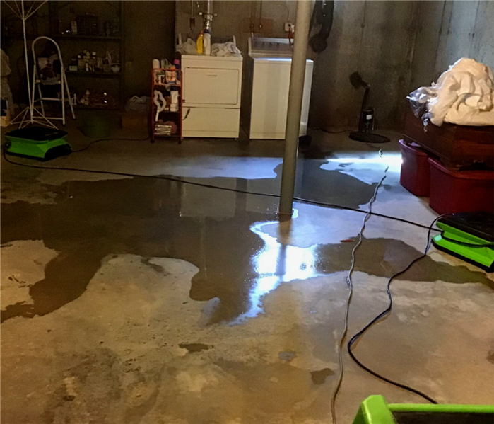 large puddle of water on concrete basement floor after rain